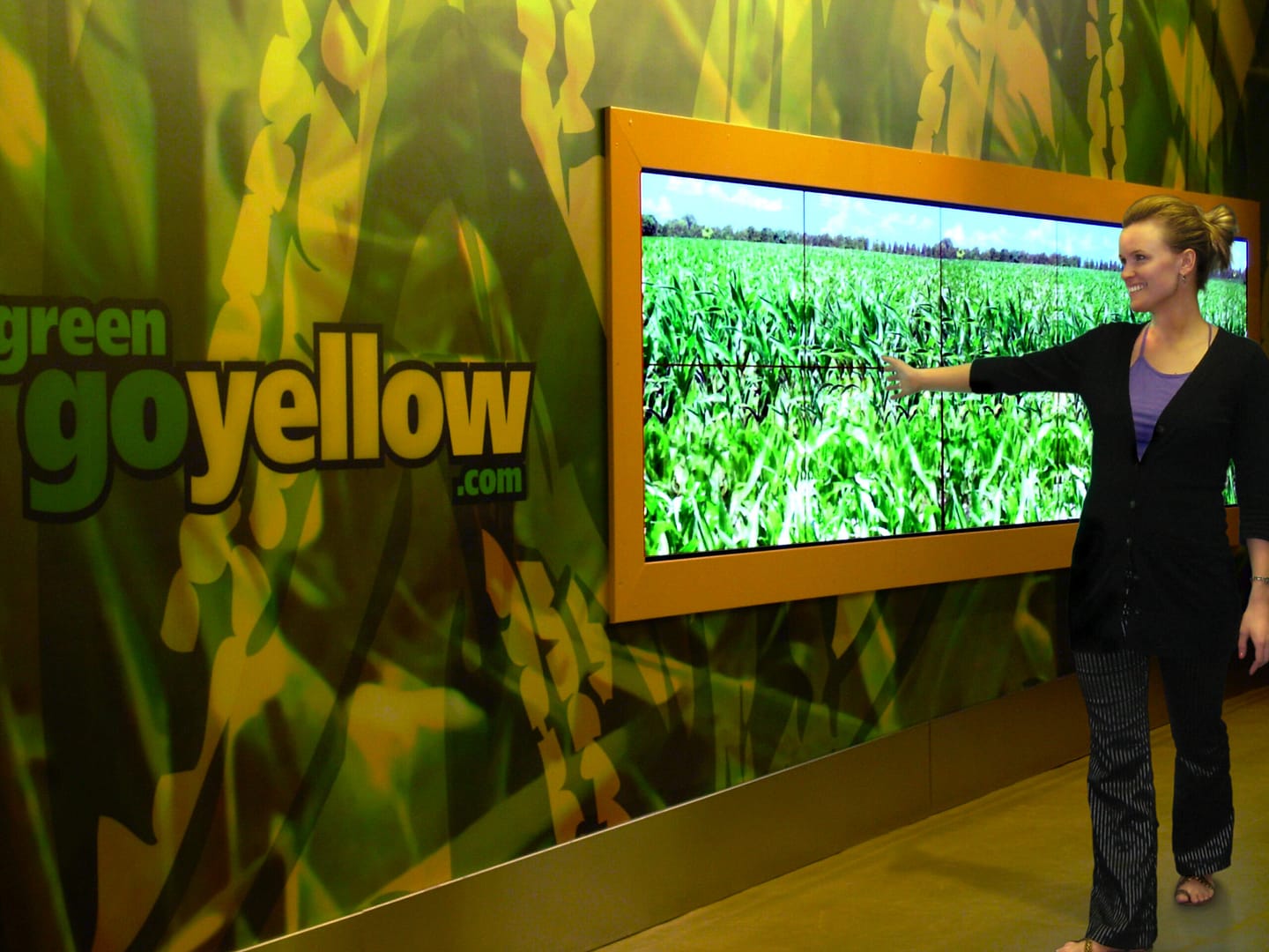 Person controlling a large wall-mounted screen with an arm gesture